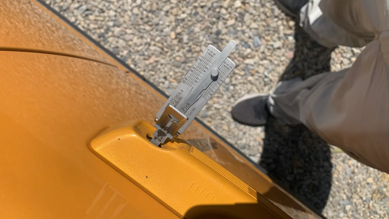 Lishi tool in an orange car door lock during a car lockout